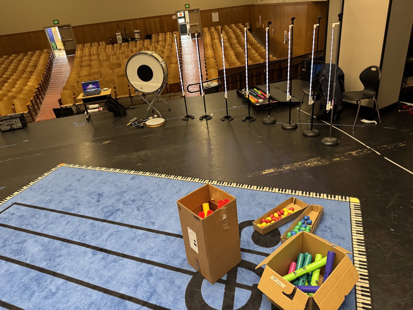 Open boxes of percussion tubes sorted by color, resting on the mat.